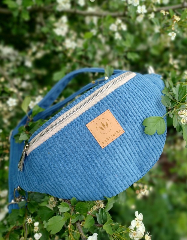 Niebieska torebka nerka to idealny dodatek do miejskich i sportowych stylizacji. Wykonana z modnego, prążkowanego materiału, lekka i pojemna, zapewnia wygodę noszenia na co dzień. Idealna na spacer, zakupy i podróż.