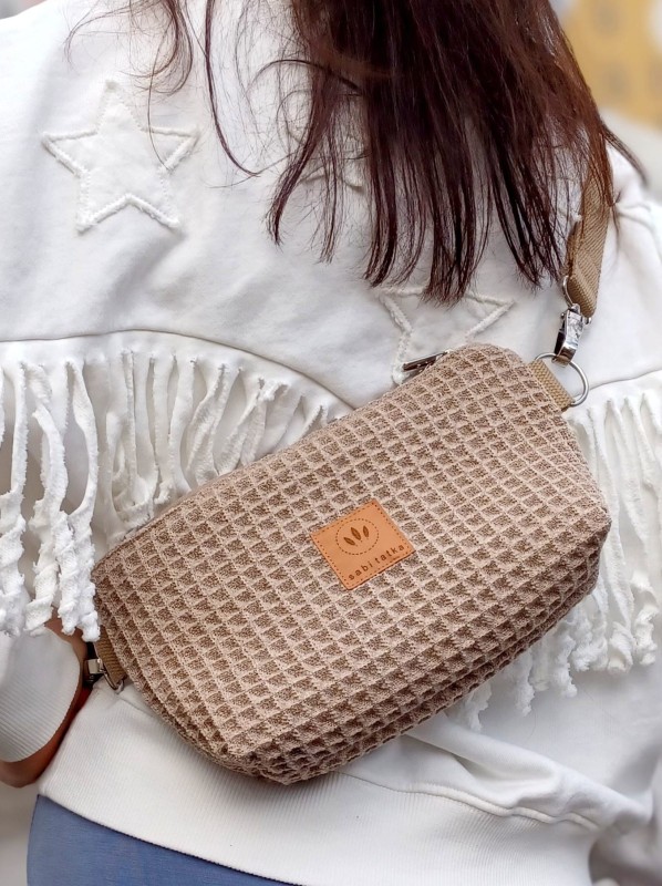 Waflowa torebka crossbody w kolorze beżowym – lekka, stylowa i praktyczna. Miękka faktura, regulowany pasek i nowoczesny design idealne na co dzień, spacery po mieście i stylizacje casual oraz lifestyle.