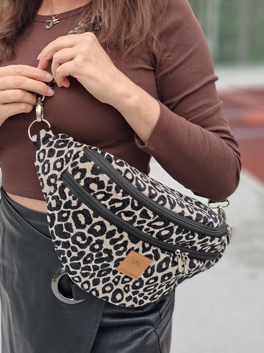 Stylowa nerka w panterkę wyróżnia się wyrazistym, zwierzęcym wzorem.  Komora główna oraz dodatkowe kieszenie na zamek pozwalają  przechowywać najważniejsze rzeczy. Regulowany pasek umożliwia noszenie nerki na biodrach lub przez ramię.