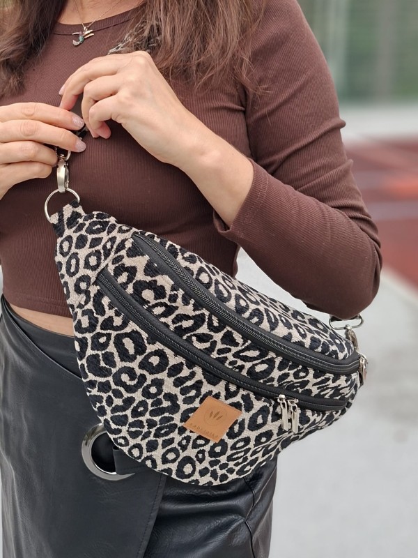 Stylowa nerka w panterkę wyróżnia się wyrazistym, zwierzęcym wzorem.  Komora główna oraz dodatkowe kieszenie na zamek pozwalają  przechowywać najważniejsze rzeczy. Regulowany pasek umożliwia noszenie nerki na biodrach lub przez ramię.