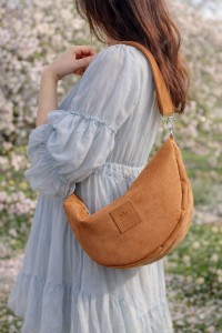 Zamszowa torebka rogalik noszona na skos doskonale uzupełnia romantyczne stylizacje i codzienne outfity. Modny rudy kolor oraz wygodny fason sprawiają, że torebka świetnie sprawdzi się na wyjście do miasta lub w podróży.