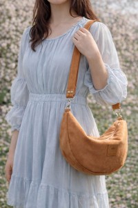 Zamszowa torebka rogalik noszona na skos doskonale uzupełnia romantyczne stylizacje i codzienne outfity. Modny rudy kolor oraz wygodny fason sprawiają, że torebka świetnie sprawdzi się na wyjście do miasta lub w podróży.