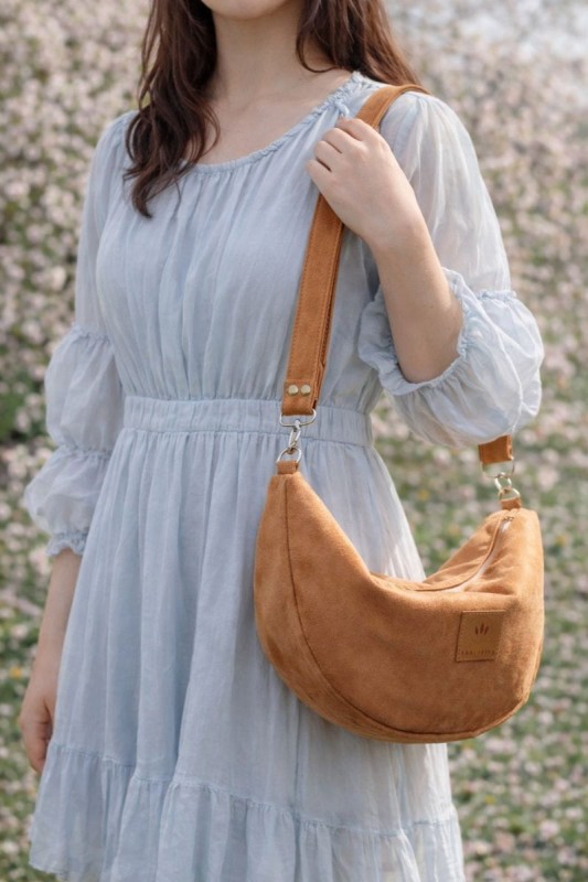 Zamszowa torebka rogalik noszona na skos doskonale uzupełnia romantyczne stylizacje i codzienne outfity. Modny rudy kolor oraz wygodny fason sprawiają, że torebka świetnie sprawdzi się na wyjście do miasta lub w podróży.