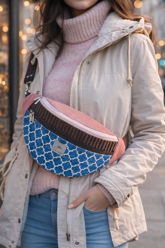 Kolorowa torebka nerka o geometrycznym wzorze, wykonana z wysokiej jakości tkanin. Stylowa i funkcjonalna, idealna do miejskich stylizacji. Regulowany pasek, praktyczne zapięcie i nowoczesny design