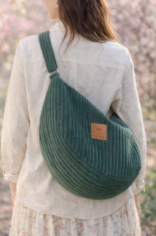 Zielona sztruksowa torba typu hobo o miękkiej formie i minimalistycznym designie. Stylowa, pojemna i wygodna na co dzień, idealna do miejskich i wiosennych stylizacji. Naturalny materiał, modny kolor.