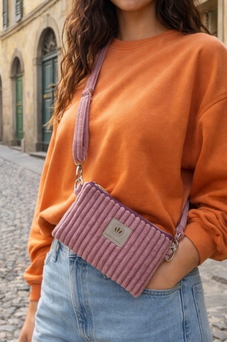 Stylowa saszetka crossbody z miękkiego, prążkowanego materiału w pudrowym odcieniu różu/wrzosowym. Praktyczna, lekka i wygodna, idealna na co dzień i w podróży. Rękodzieło, casualowy styl.