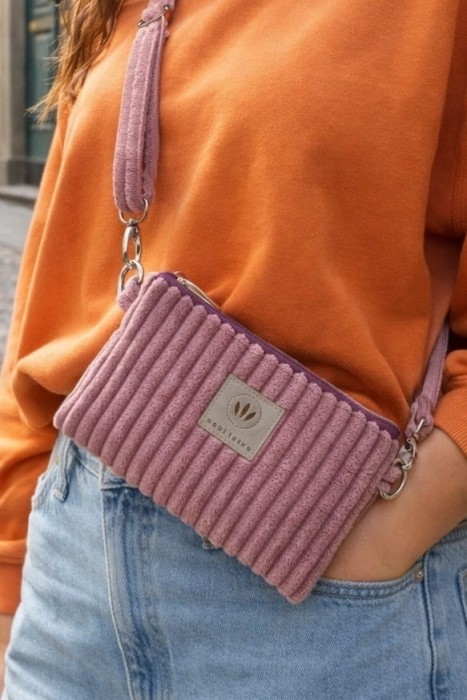 Stylowa saszetka crossbody z miękkiego, prążkowanego materiału w pudrowym odcieniu różu/wrzosowym. Praktyczna, lekka i wygodna, idealna na co dzień i w podróży. Rękodzieło, casualowy styl.
