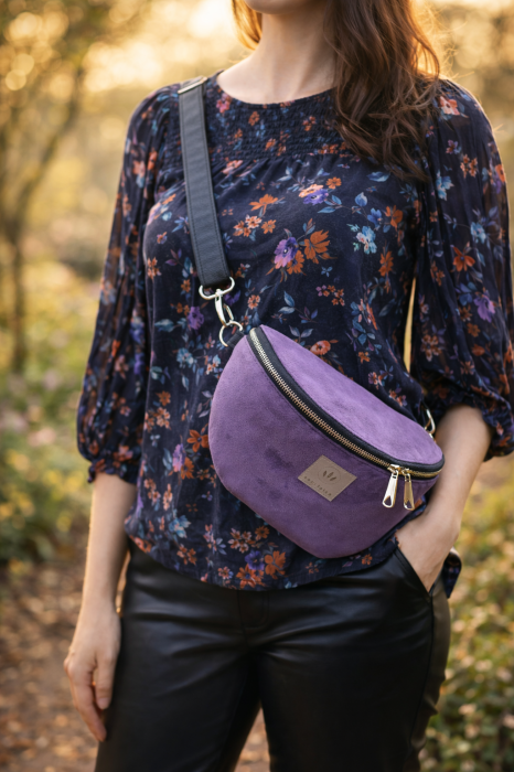 Fioletowa zamszowa nerka damska o eleganckim, minimalistycznym designie. Miękka w dotyku, z regulowanym paskiem i solidnym zamkiem. Idealna na co dzień i do stylizacji casual oraz lifestyle.