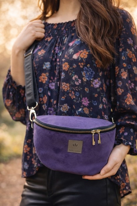 Fioletowa zamszowa nerka damska o eleganckim, minimalistycznym designie. Miękka w dotyku, z regulowanym paskiem i solidnym zamkiem. Idealna na co dzień i do stylizacji casual oraz lifestyle.