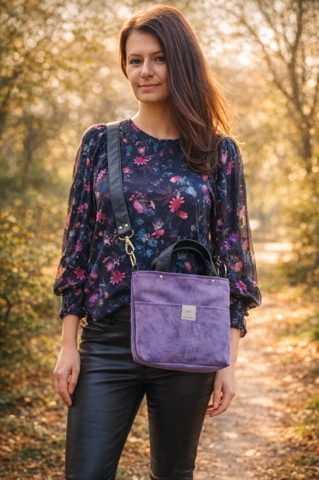 Fioletowa zamszowa torebka damska na ramię, noszona na skos. Miękka faktura, minimalistyczny fason i wygodny pasek. Idealna na co dzień i spacery, styl casual i lifestyle.