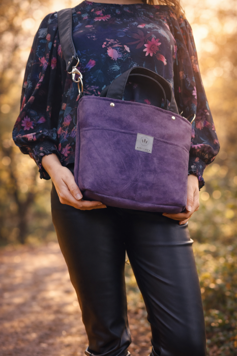 Fioletowa zamszowa torebka damska na ramię, noszona na skos. Miękka faktura, minimalistyczny fason i wygodny pasek. Idealna na co dzień i spacery, styl casual i lifestyle.