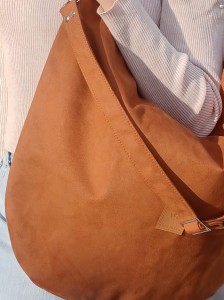 Stylowa zamszowa torba w ciepłym brązowym kolorze, o miękkiej formie i nowoczesnym kształcie. Idealna do codziennych stylizacji, pojemna, wygodna i wykonana z wysokiej jakości zamszu.