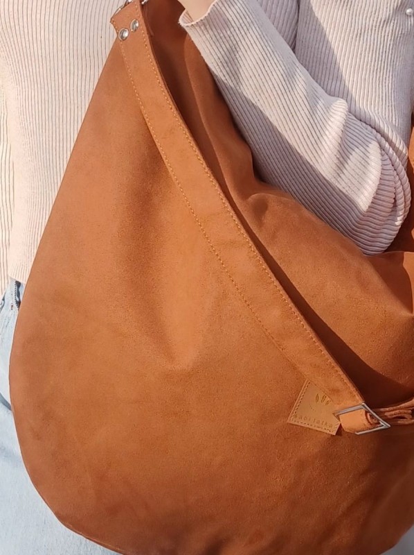 Stylowa zamszowa torba w ciepłym brązowym kolorze, o miękkiej formie i nowoczesnym kształcie. Idealna do codziennych stylizacji, pojemna, wygodna i wykonana z wysokiej jakości zamszu.