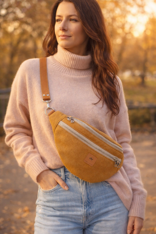 Stylowa nerka z nubuku w ciepłym miodowym odcieniu. Miękka, trwała faktura, modny półokrągły kształt i regulowany pasek. Idealna do miejskich i casualowych stylizacji, łączy funkcjonalność z nowoczesnym designem.