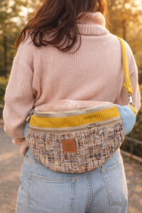 Pojemna nerka damska w miejskim wydaniu. Wykonana z tkaniny tweedowej w pastelowej kolorystyce, z kontrastowymi akcentami w odcieniach błękitu i musztardowej żółci. Idealna jako nerka przez ciało – świetny wybór do casualowych i miejskich stylizacji.