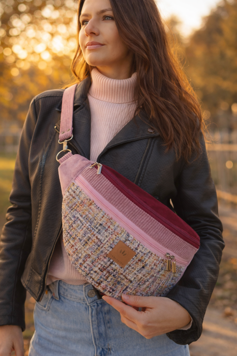 Kolorowa nerka maxi o półokrągłym kształcie, wykonana z miękkiej, wielobarwnej tkaniny o wyrazistej fakturze. Różowe detale i regulowany pasek dodają jej stylu i funkcjonalności. Idealna na co dzień.