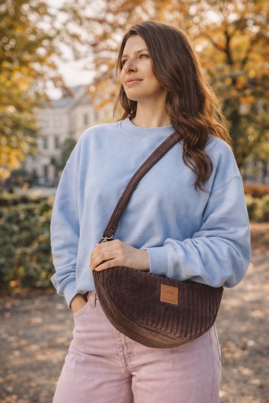 Sztruksowa nerka w kształcie półksiężyca to stylowy i praktyczny dodatek na co dzień. Miękka faktura, modny design i wygodne noszenie crossbody sprawdzą się w miejskich stylizacjach przez cały rok.