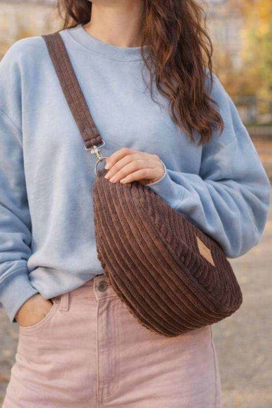 Sztruksowa nerka w kształcie półksiężyca to stylowy i praktyczny dodatek na co dzień. Miękka faktura, modny design i wygodne noszenie crossbody sprawdzą się w miejskich stylizacjach przez cały rok.