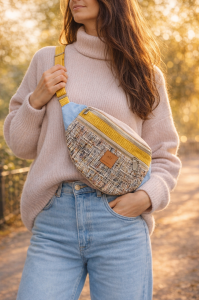 Torebka nerka damska w miejskim wydaniu. Wykonana z tkaniny tweedowej w pastelowej kolorystyce, z kontrastowymi akcentami w odcieniach błękitu i musztardowej żółci. Idealna jako nerka przez ciało – świetny wybór do casualowych i miejskich stylizacji.