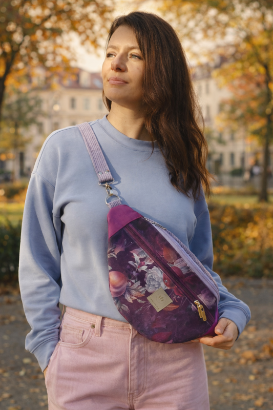 Stylowa maxi nerka w kwiatowy wzór, w odcieniach śliwki i fioletu. Pojemna, wygodna, z regulowanym paskiem. Idealna na co dzień i miejskie spacery – modny dodatek lifestyle.