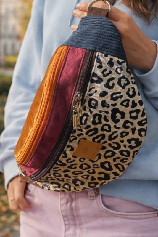 Kolorowa, pojemna nerka z regulowanym paskiem, wykonana z wytrzymałych tkanin. Modny wzór panterki, praktyczne kieszenie na zamek. Idealna na co dzień, spacery i podróże.