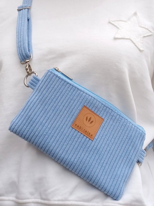 Błękitna sztruksowa torebka na telefon z regulowanym paskiem. Lekka, praktyczna i stylowa – idealna na co dzień i podróże. Modny kolor, miękka faktura, miejsce na telefon i drobiazgi.