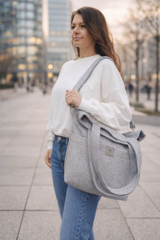 Nowoczesna, szara torebka shopper z wytrzymałej tkaniny, idealna do codziennego użytku. Minimalistyczny design, pojemne wnętrze i wygodne paski sprawiają, że doskonale pasuje do miejskich, casualowych stylizacji.