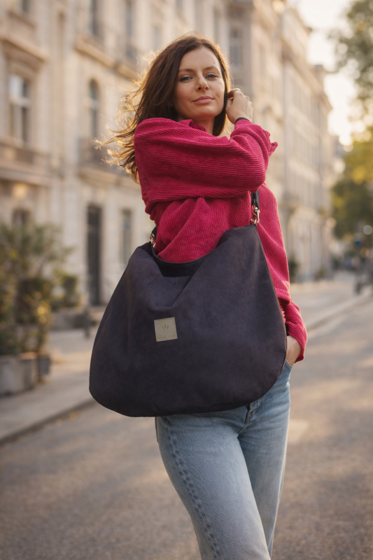 Czarna zamszowa torba hobo o miękkiej formie i eleganckim charakterze. Stylowa, pojemna i wygodna na ramię – idealna do codziennych i miejskich stylizacji. Ponadczasowy design i wysoka jakość wykonania.