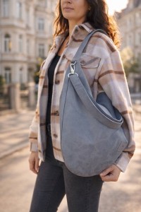 Zamszowa torba hobo w eleganckim, miejskim stylu. Miękka, lekka i pojemna, idealna na co dzień. Ponadczasowy kształt, naturalna faktura zamszu i wygodne noszenie na ramieniu. Stylowa torba damska do miasta.