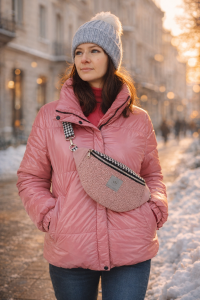 Różowa nerka o półokrągłym kształcie, wykonana z miękkiej, strukturalnej tkaniny. Posiada czarny zamek, regulowany pasek we wzór pepitki oraz metalowe detale. Noszona na skos, stylowa i praktyczna.