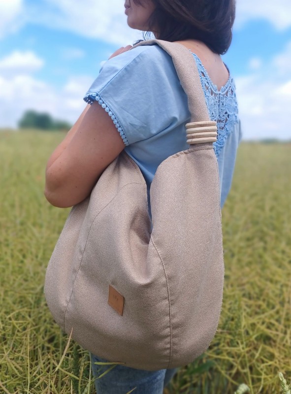 Torba worek z lnianej plecionki o miękkiej, naturalnej fakturze. Lekka, pojemna i wygodna, idealna na co dzień. Subtelny, minimalistyczny design w neutralnym kolorze pasuje do stylizacji casual i boho.