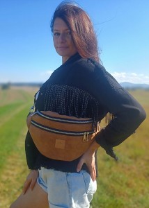 Duża nerka z naturalnego zamszu w kolorze brązowym karmelowym. Stylowa, pojemna i wygodna, z podwójnym zamkiem i regulowanym paskiem. Idealna do codziennych stylizacji i looków lifestyle.
