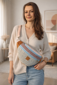 Duża nerka z tweedowej tkaniny w pastelowych kolorach z  regulowanym paskiem. Stylowa, pojemna i wygodna, idealna do miejskich i podróżnych stylizacji casualowych.