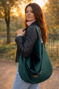 Duża, stylowa torebka w kolorze butelkowej zieleni, wykonana z miękkiego, aksamitnego materiału. Posiada wygodny pasek na ramię, solidne metalowe okucia oraz subtelne logo, idealna do codziennych miejskich stylizacji.