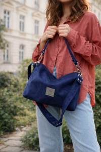 Mała zamszowa torebka w kolorze głębokiego granatu, elegancka i funkcjonalna. Miękka faktura, regulowany pasek i minimalistyczny design sprawiają, że idealnie pasuje do codziennych i eleganckich stylizacji.