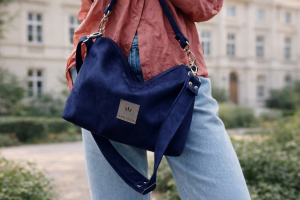 Mała zamszowa torebka w kolorze głębokiego granatu, elegancka i funkcjonalna. Miękka faktura, regulowany pasek i minimalistyczny design sprawiają, że idealnie pasuje do codziennych i eleganckich stylizacji.