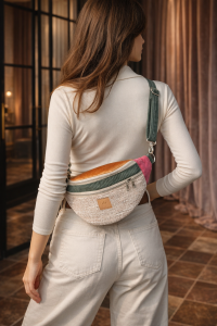 Duża nerka z tweedowej tkaniny w pastelowych kolorach z  regulowanym paskiem. Stylowa, pojemna i wygodna, idealna do miejskich i podróżnych stylizacji casualowych.