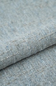 Duża nerka z tweedowej tkaniny w pastelowych kolorach z  regulowanym paskiem. Stylowa, pojemna i wygodna, idealna do miejskich i podróżnych stylizacji casualowych.