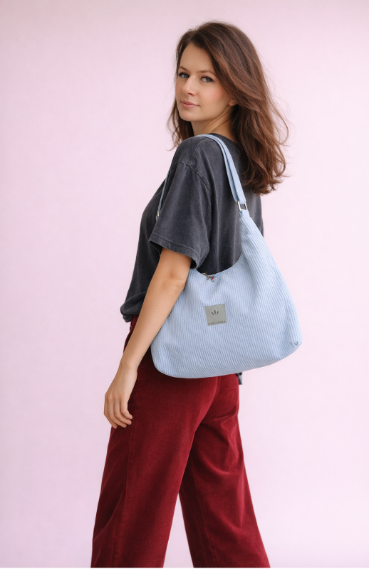 Stylowa torba hobo z miękkiego sztruksu w jasnym błękicie. Pojemny, wygodny fason na ramię, idealny na co dzień. Minimalistyczny design, modna faktura i praktyczny, uniwersalny charakter.