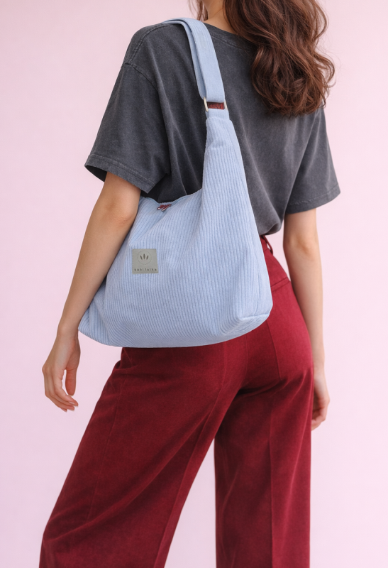 Stylowa torba hobo z miękkiego sztruksu w jasnym błękicie. Pojemny, wygodny fason na ramię, idealny na co dzień. Minimalistyczny design, modna faktura i praktyczny, uniwersalny charakter.