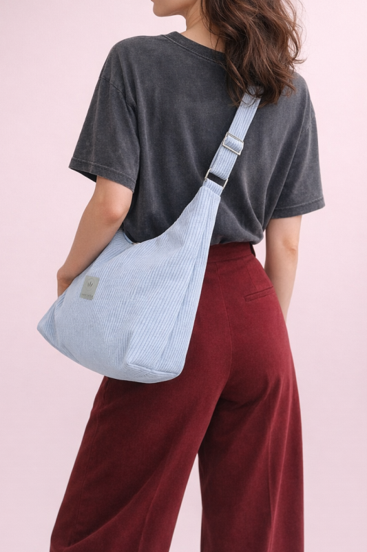 Stylowa torba hobo z miękkiego sztruksu w jasnym błękicie. Pojemny, wygodny fason na ramię, idealny na co dzień. Minimalistyczny design, modna faktura i praktyczny, uniwersalny charakter.