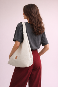 Elegancka zamszowa torba hobo w jasnym odcieniu kremowym to idealny dodatek na co dzień i do stylizacji premium. Miękka faktura, minimalistyczny design i pojemne wnętrze łączą modę z funkcjonalnością.