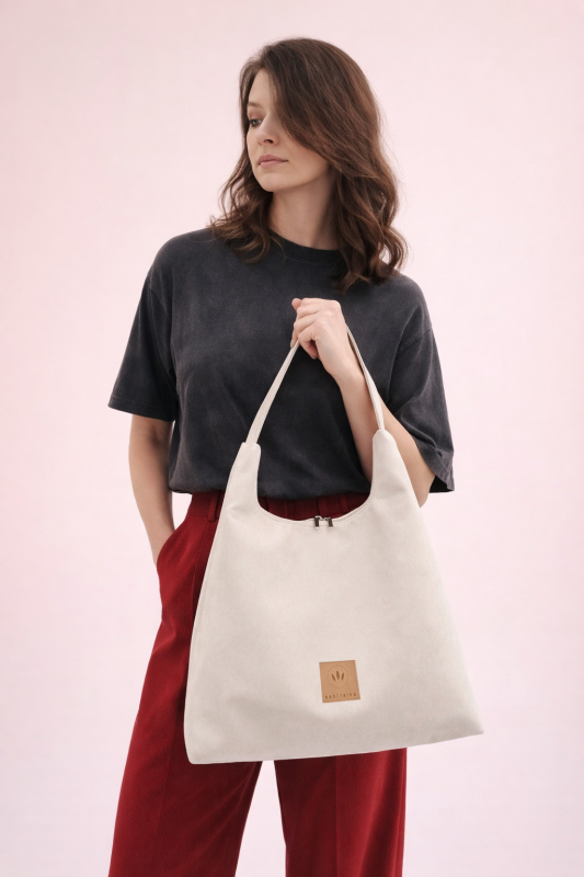 Elegancka zamszowa torba hobo w jasnym odcieniu kremowym to idealny dodatek na co dzień i do stylizacji premium. Miękka faktura, minimalistyczny design i pojemne wnętrze łączą modę z funkcjonalnością.