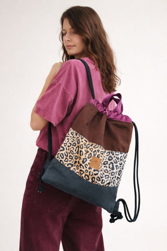Kolorowy plecak worek z modnym motywem panterki, łączący różne faktury i odcienie. Lekki, pojemny i wygodny – idealny na co dzień, zakupy lub spacer. Stylowy dodatek do miejskich i casualowych stylizacji.