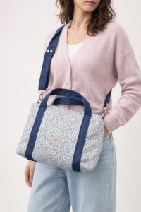 Stylowa torebka z plecionki o eleganckim, prostokątnym kształcie. Jasnoniebieska struktura z granatowymi uchwytami i regulowanym paskiem łączy naturalną fakturę z nowoczesnym designem. Lekka, pojemna i idealna na co dzień.