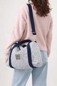 Stylowa torebka z plecionki o eleganckim, prostokątnym kształcie. Jasnoniebieska struktura z granatowymi uchwytami i regulowanym paskiem łączy naturalną fakturę z nowoczesnym designem. Lekka, pojemna i idealna na co dzień.