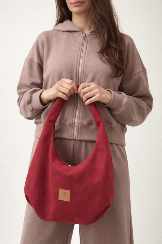 Zamszowa torba hobo w intensywnym czerwonym kolorze to stylowy dodatek do miejskich stylizacji. Miękka, pojemna i wygodna w noszeniu na ramieniu, łączy modny design z funkcjonalnością. Idealna do casualowych i streetwearowych zestawów.