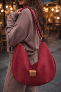 Zamszowa torba hobo w głębokim, czerwonym kolorze. Miękka, pojemna i lekka, z wygodnym paskiem na ramię. Stylowy, półokrągły kształt i minimalistyczny design sprawiają, że idealnie dopełnia miejskie i casualowe stylizacje.