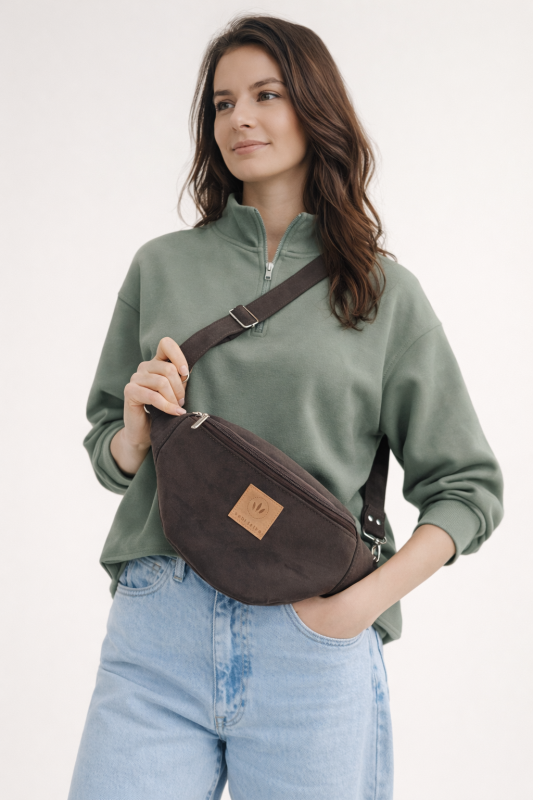 Czekoladowa zamszowa nerka to stylowy i praktyczny dodatek na co dzień. Miękka faktura, modny fason i wygodny pasek sprawiają, że idealnie sprawdzi się w miejskich stylizacjach, zapewniając komfort noszenia i elegancki wygląd.