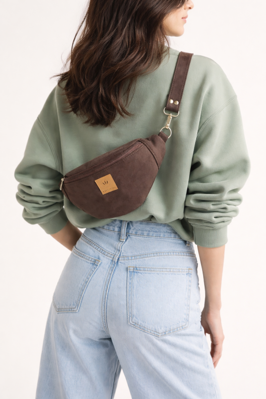 Czekoladowa zamszowa nerka to stylowy i praktyczny dodatek na co dzień. Miękka faktura, modny fason i wygodny pasek sprawiają, że idealnie sprawdzi się w miejskich stylizacjach, zapewniając komfort noszenia i elegancki wygląd.